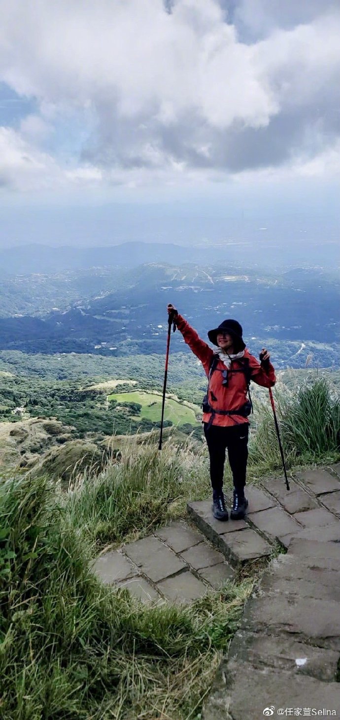 腳踩登山鞋,還帶了登山棍,裝備齊全,在山上和風景開心自拍,並伸手指