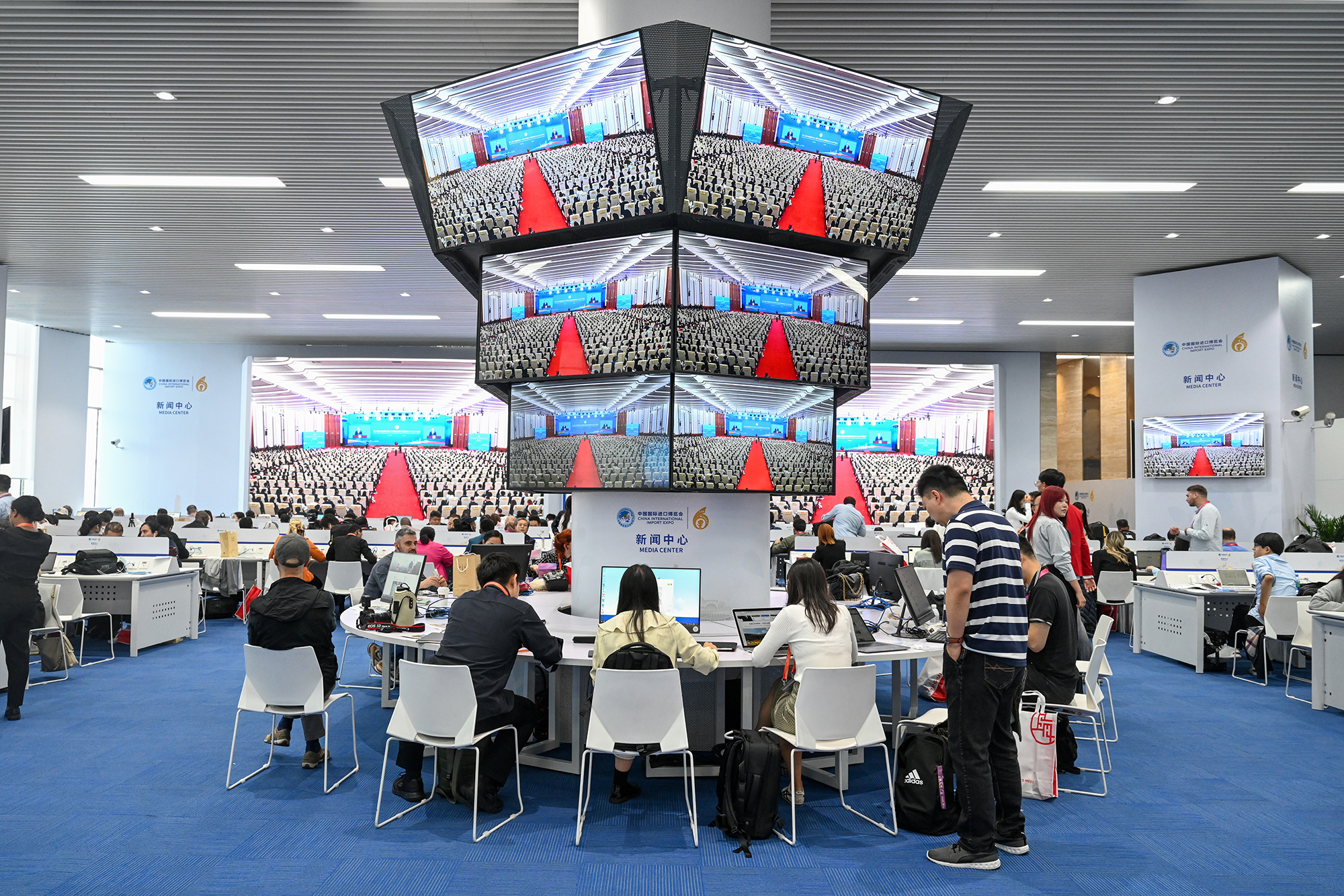 中外媒体记者在新闻中心聚焦第六届进博会开幕式。