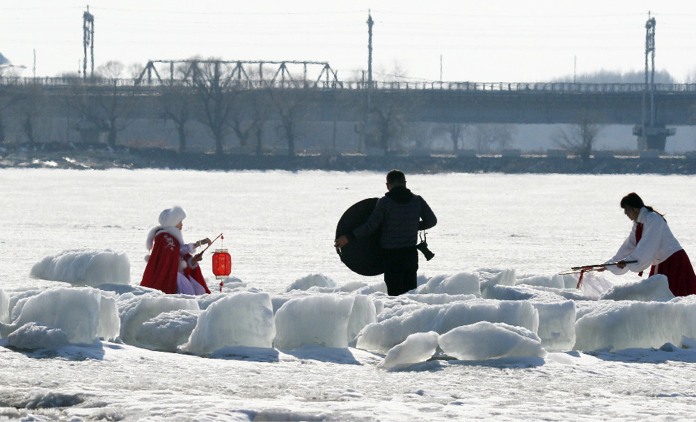 2021年3月23日，黑龙江省哈尔滨市，下午，最高气温已达13℃，为今年来最高。松花江岸边的采冰场，冰块正在消融，不少市民在此穿着古装拍照，春意浓浓。