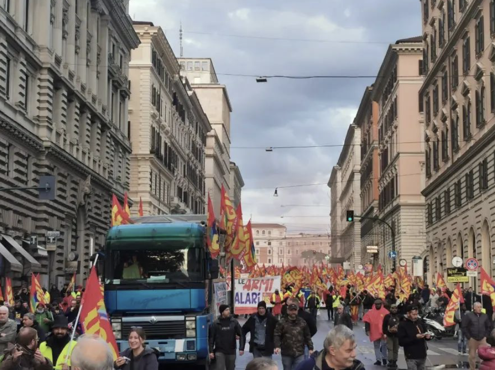 意大利基层工会联盟称，当地时间12月3日在罗马举行了口号为“放下武器，提高工资”的抗议活动。