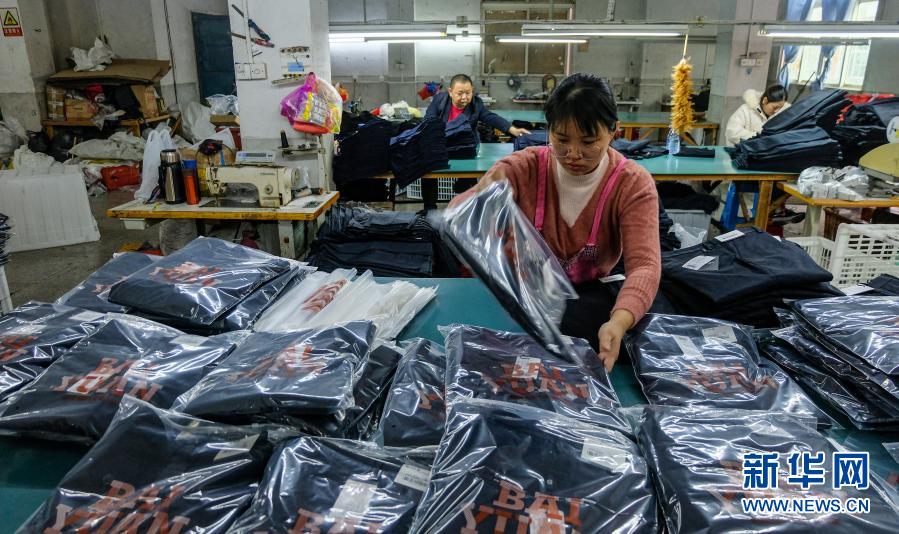 12月4日,来自政和县的村民杨珊在石狮一家服装加工厂车间包装西裤.
