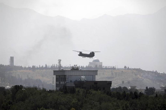 一架美軍直升機降落喀布爾美國大使館，也有人看到疑似燒文件的煙霧，顯然美國在阿富汗最後撤離行動已經進行。 圖自美聯社