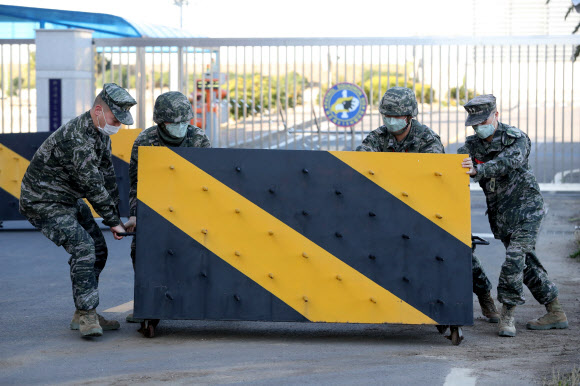 韩国某部队正门前，官兵们设置路障防疫（韩联社）