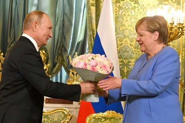 （2021年8月，默克尔最后一次访俄，俄罗斯总统普京送上鲜花）