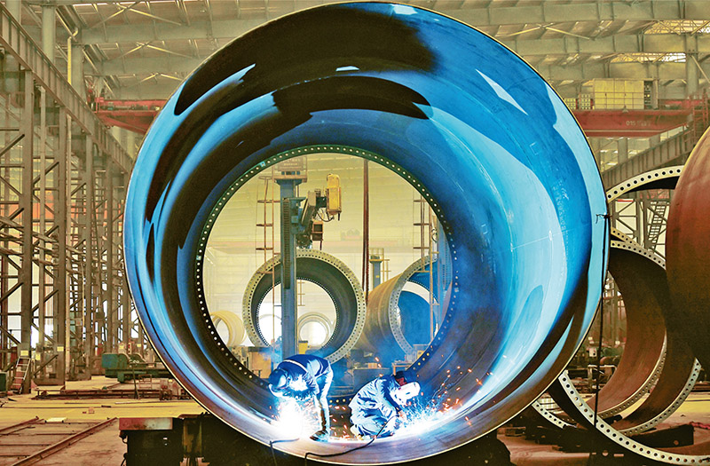 苏州天顺新能源科技有限公司生产人员正在焊接风电塔筒单节筒体,奋力