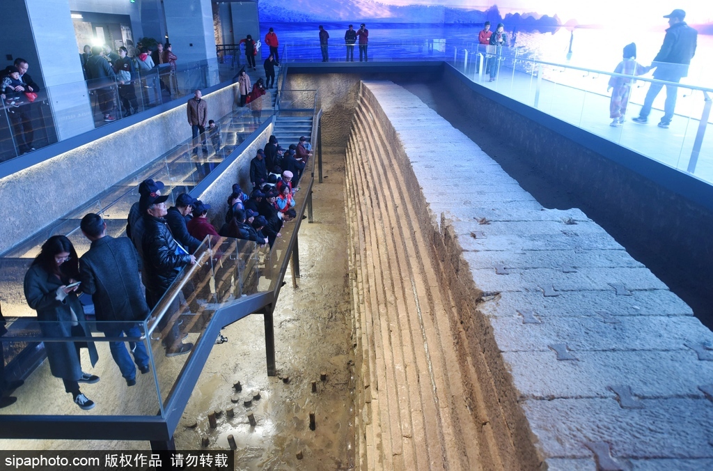 图为观众正在观看古代海塘遗址