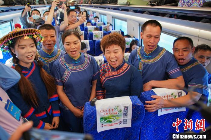 乘坐贵南高铁首发G4308次列车的广西环江毛南族自治县毛南族民众在车上唱响迎客歌。陈冠言 摄