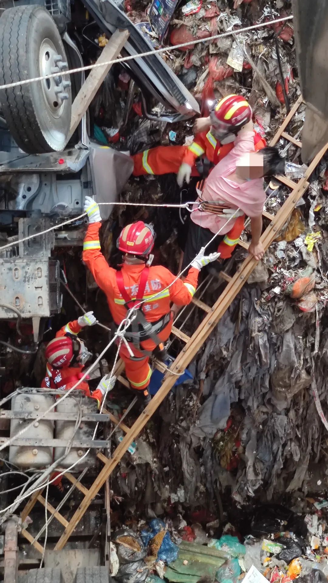 广东一垃圾车坠入14米深坑消防顶着恶臭搭梯救人
