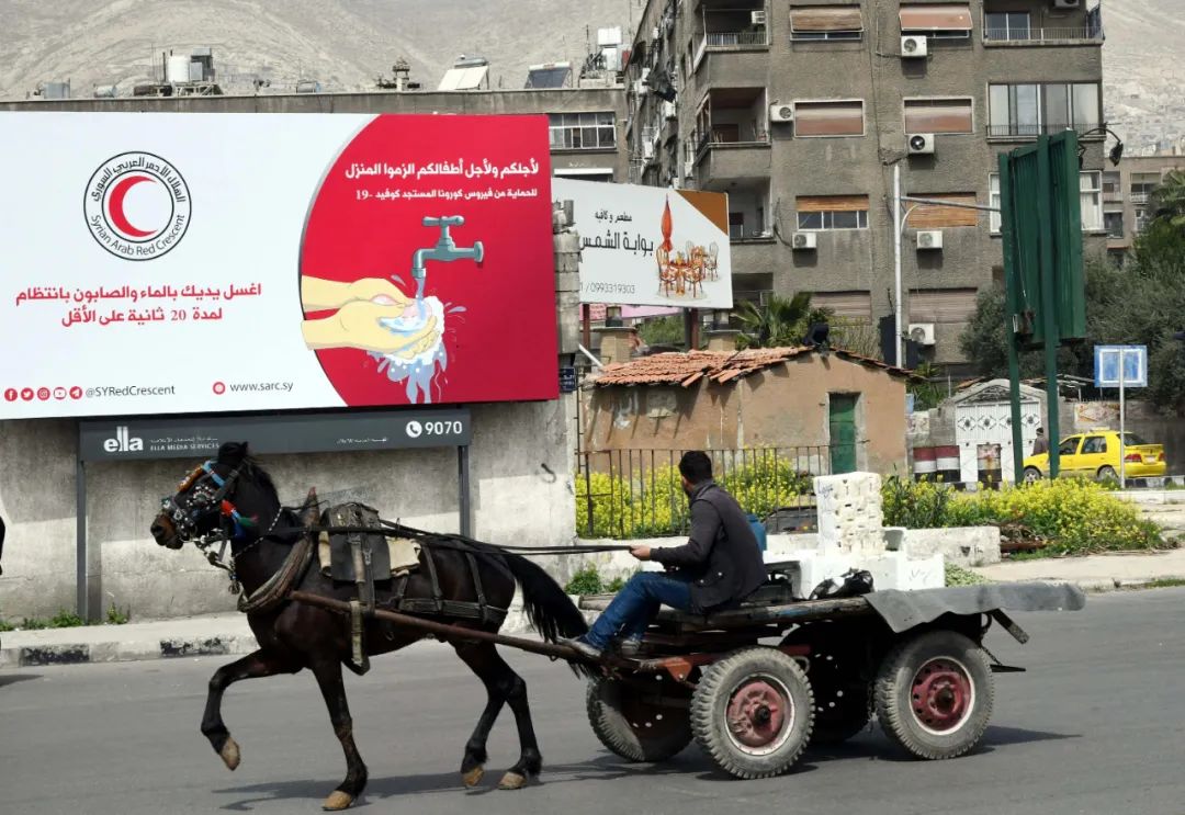 3月25日，在叙利亚大马士革，一名男子路过一处新冠肺炎应对措施的宣传栏。新华社发（阿马尔·萨法尔贾拉尼摄）
