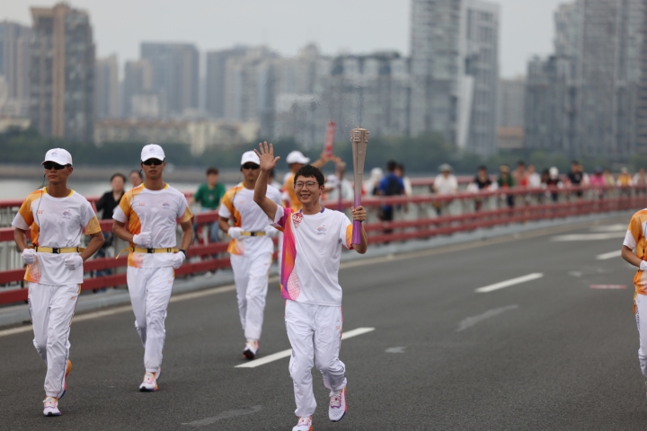随着彭清林接过火炬向前奔跑,人群中传来阵阵喝彩和欢呼.