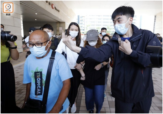 陈彦霖的外公(蓝衣)及母亲(白衣)昨日离开法庭时遭人举中指滋扰。（图源：香港“东网”）
